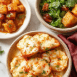 A vibrant autumn-inspired table featuring a variety of healthy fall meals. The plates display colorful roasted vegetables, hearty soups, and warm casseroles with textures from creamy stews to crisp roasted toppings. The scene is styled with fall leaves, candles, and rustic dishware, evoking a cozy and inviting atmosphere perfect for seasonal comfort food.